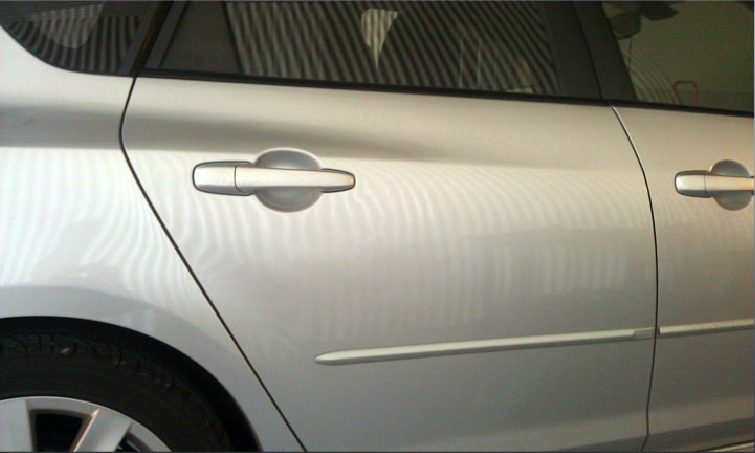 The same silver car door after paintless dent repair, smooth with no dent